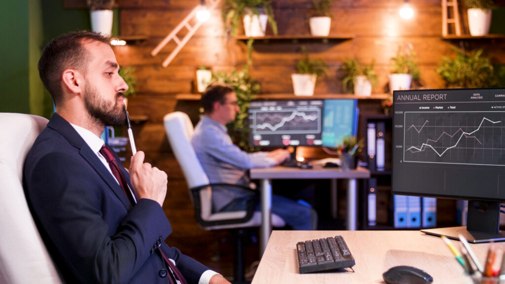 businessman thinking in front of his monitors in the office